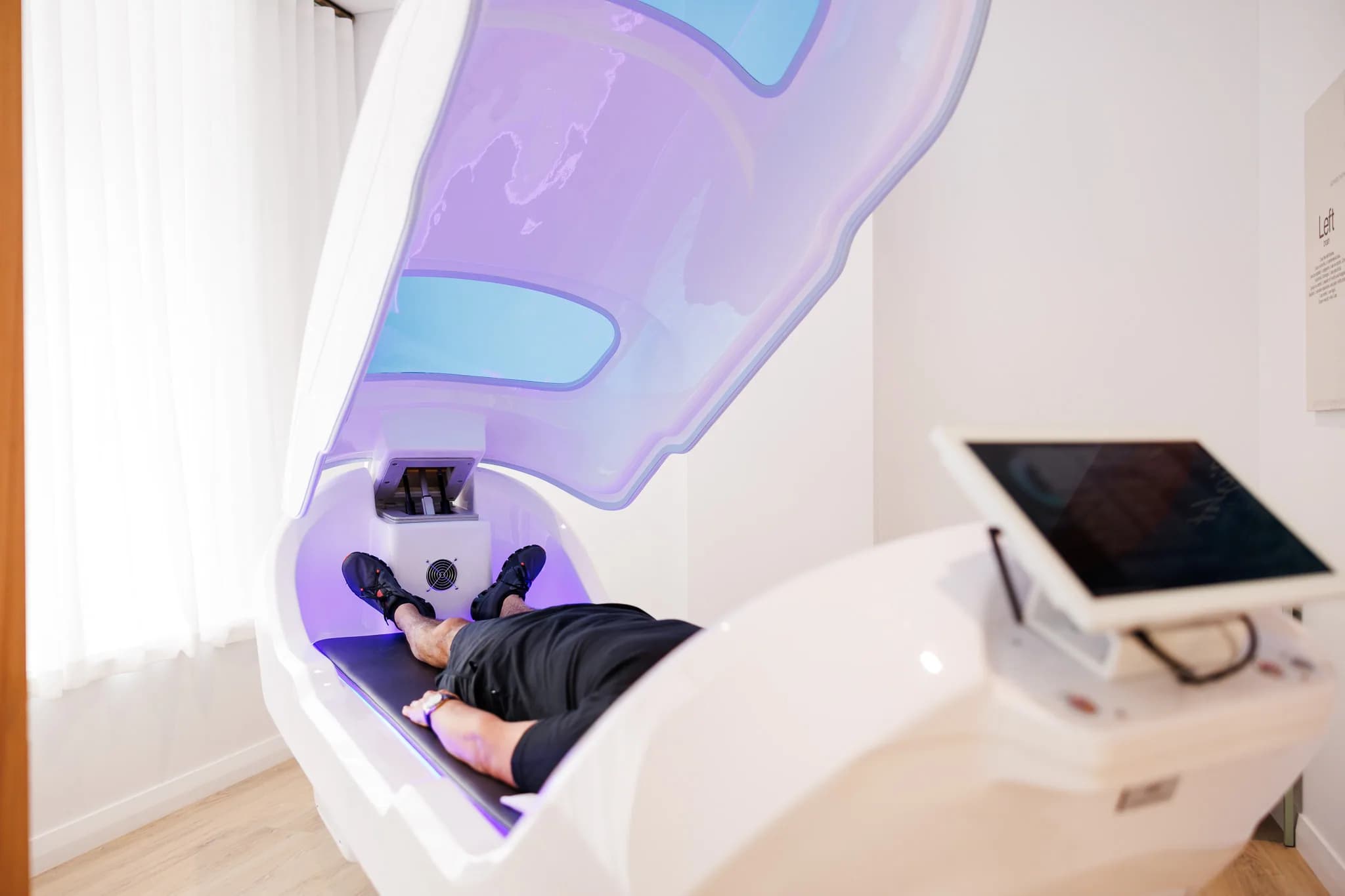 Foot-angle view of a man inside the Theta chamber pod