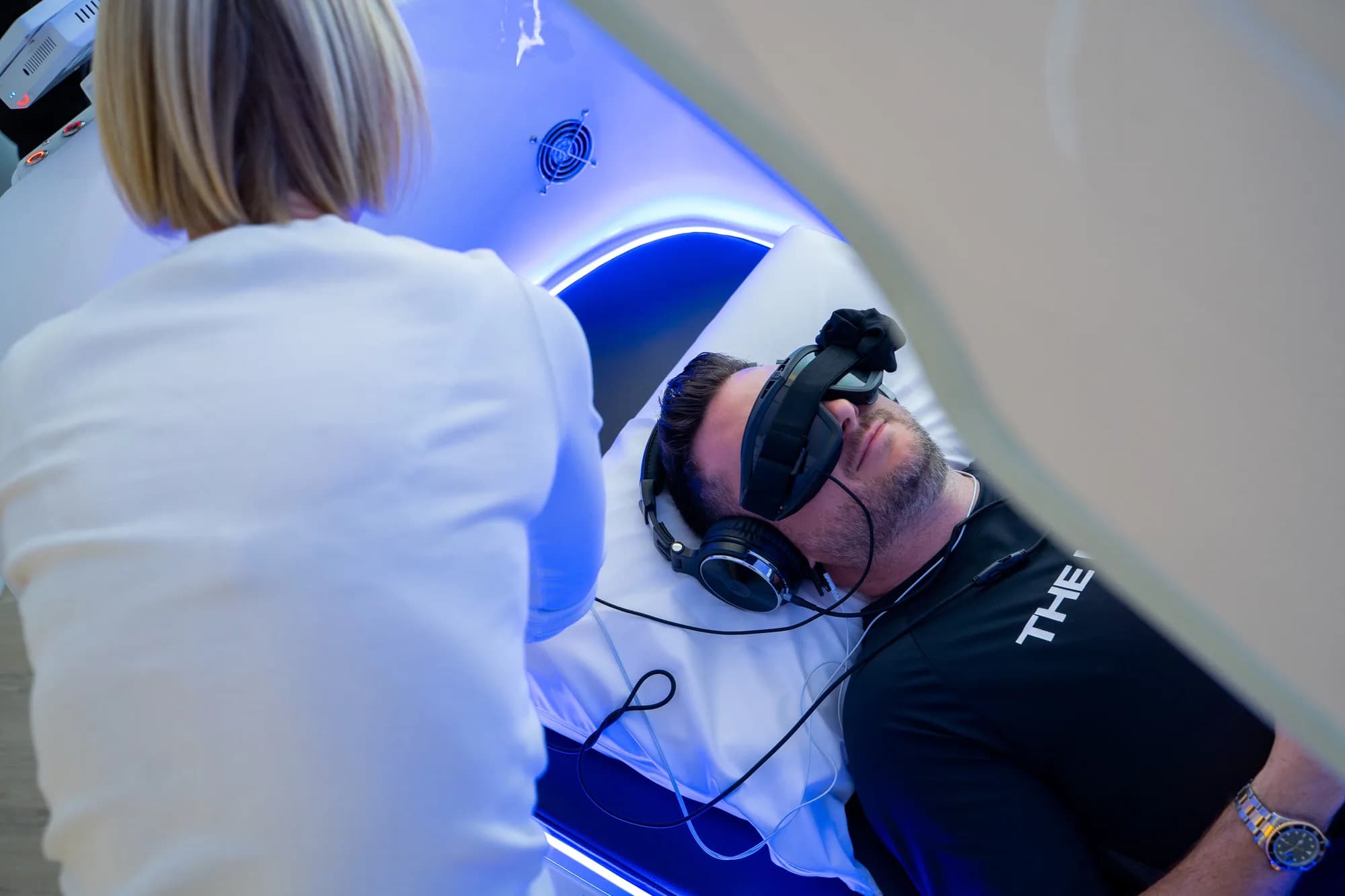Practitioner fitting goggles before a Theta chamber session